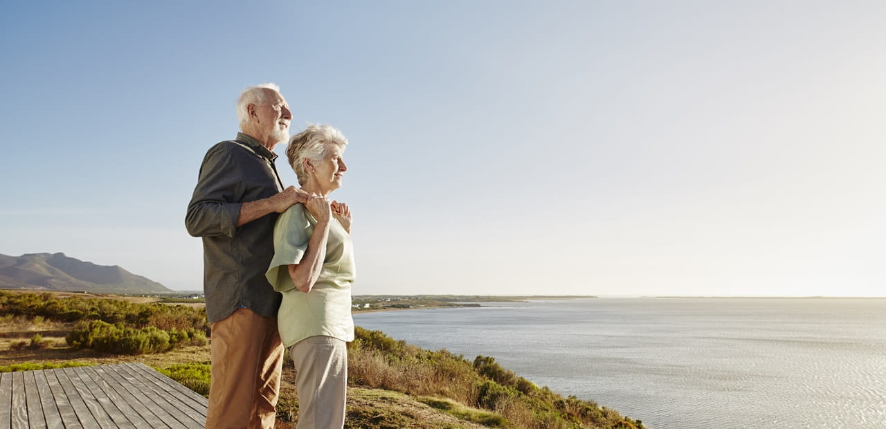 Senior couple enjoying the view on wooden terrace at the sea