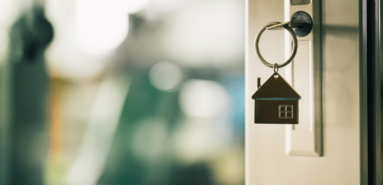 House model and key in house door.